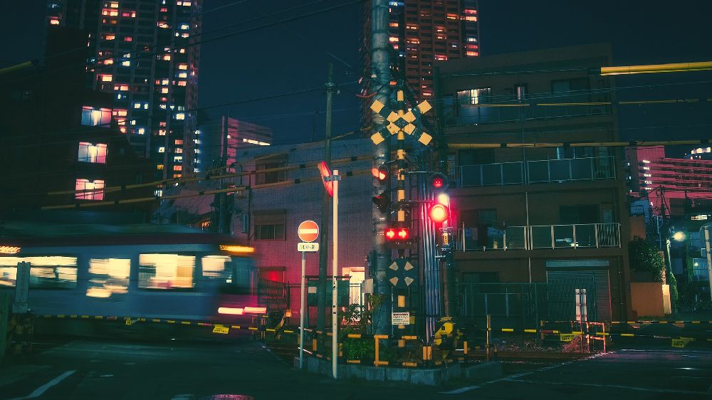 大阪市北区の夜の街を走る快速電車