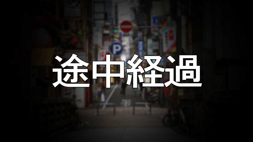 中央に「途中経過」と書かれた大阪の街の写真です。街の景色はぼかしを掛けています。