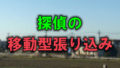 大阪のとある住宅街を畑の向こう側から写した写真に「探偵の移動型張り込み」と書かれた画像です。